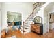 Inviting foyer with hardwood floors, a staircase with wood and iron railing, and a view into the living room at 7732 Wingmont Dr, Charlotte, NC 28269