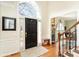 Welcoming foyer with a large front door, hardwood floors, and a view into the dining room, with a staircase to the right at 7732 Wingmont Dr, Charlotte, NC 28269