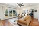 Sunlit living room features hardwood floors, large windows with backyard views, and an adjacent kitchen at 7732 Wingmont Dr, Charlotte, NC 28269