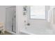 Bathroom with a soaking tub, framed shower with glass doors, and a window with blinds at 8028 Tricia Pointe Pl, Indian Land, SC 29707