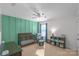 A well-lit Bedroom with a crib, ceiling fan, comfortable rocking chair and a bookcase, and a green accent wall at 8028 Tricia Pointe Pl, Indian Land, SC 29707