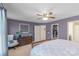 Bright primary bedroom featuring a ceiling fan, an upholstered armchair, and a large walk-in closet at 8028 Tricia Pointe Pl, Indian Land, SC 29707