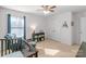 A well-lit Bedroom with a crib, ceiling fan, comfortable rocking chair and a bookcase, and a neutral color palette at 8028 Tricia Pointe Pl, Indian Land, SC 29707