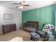 A well-lit Bedroom with a crib, ceiling fan, comfortable rocking chair and a bookcase, and a green accent wall at 8028 Tricia Pointe Pl, Indian Land, SC 29707