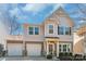 Charming two-story home boasts a three-car garage, complemented by tasteful stone and shingle accents at 8028 Tricia Pointe Pl, Indian Land, SC 29707