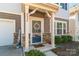 Inviting front porch featuring stone accents, decorative wreath, and cozy 