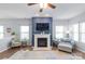 Inviting living room featuring a fireplace, ceiling fan, and natural light from bright windows at 8028 Tricia Pointe Pl, Indian Land, SC 29707