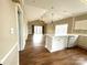 Open concept living area featuring a kitchen with white cabinets and a spacious breakfast bar area at 8668 Coralbell Ln # 10, Charlotte, NC 28213
