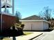 Exterior view of the garages near building 10, surrounded by greenery on a sunny day at 8668 Coralbell Ln # 10, Charlotte, NC 28213