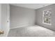 Simple bedroom features neutral walls, plush carpet, and a bright window at 9014 Arbor Creek Dr, Charlotte, NC 28269