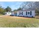 View of the white vinyl-sided house featuring a teal front door and a well-maintained lawn at 910 Mcdow Dr, Rock Hill, SC 29732