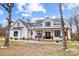 Beautifully landscaped modern farmhouse with a welcoming front porch, rocking chairs, and mature trees at 957 Hathcock Glen Dr, Oakboro, NC 28129