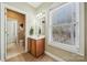 Bathroom featuring a window with blind and wooded vanity at 10620 S Ford Rd, Charlotte, NC 28214