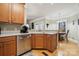 Kitchen area with views of dining area, stainless dishwasher, and wood cabinets at 10620 S Ford Rd, Charlotte, NC 28214