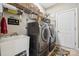 Well-equipped laundry room with modern washer and dryer, sink, and storage shelves at 10620 S Ford Rd, Charlotte, NC 28214