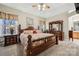 Spacious bedroom with wooden furnishings and a large bed with floral patterned bedding at 10620 S Ford Rd, Charlotte, NC 28214