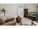 Living room featuring a beige couch, trunk, a book shelve and a TV at 10620 S Ford Rd, Charlotte, NC 28214