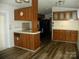 An open kitchen with wooden cabinets, laminate countertop, black appliances and laminate floor at 111 Scenic Ln, New London, NC 28127