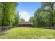 A brick home with a large, grassy backyard surrounded by trees and a fence at 11280 Mcfalls Dr, Fort Mill, SC 29707