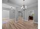 Spacious room featuring hardwood floors, neutral paint, elegant trim, and architectural columns, with chandelier at 11280 Mcfalls Dr, Fort Mill, SC 29707