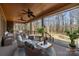 Relaxing covered patio featuring comfortable seating, ceiling fans, and a view of the serene backyard at 11280 Mcfalls Dr, Fort Mill, SC 29707