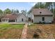 View of the home's screened porch and detached garage in a wooded backyard with a brick pathway at 1485 Sierra Rd, York, SC 29745