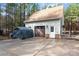 Detached garage featuring stone accents, a side entrance, carriage door, and ample driveway space at 1485 Sierra Rd, York, SC 29745