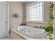 Relaxing bathtub with tile surround and a large window at 150 Canopy Oak Ln, Statesville, NC 28625