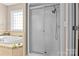 Modern bathroom featuring a glass-enclosed shower and a luxurious soaking tub near a window at 150 Canopy Oak Ln, Statesville, NC 28625