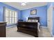 Bright bedroom featuring a dark wood bed frame, shutters, and light blue walls at 150 Canopy Oak Ln, Statesville, NC 28625
