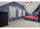 Inviting bedroom featuring three bright windows, a ceiling fan, and a classic dark wood dresser and bed frame at 150 Canopy Oak Ln, Statesville, NC 28625