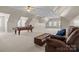 Large upper bonus room features a pool table, windows, and a seating area for versatile entertainment and relaxation at 150 Canopy Oak Ln, Statesville, NC 28625