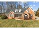 Charming brick home featuring a manicured lawn, complemented by mature trees and inviting curb appeal at 150 Canopy Oak Ln, Statesville, NC 28625