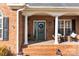 Cozy front porch with rocking chairs, brick columns, and a decorative wreath on the front door at 150 Canopy Oak Ln, Statesville, NC 28625