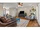 Open concept living room with hardwood floors, a stylish rug, and a decorative fireplace at 150 Canopy Oak Ln, Statesville, NC 28625