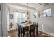 A formal dining area with a dark wood table, decorative lighting and multiple bright windows at 2112 Balting Glass Dr, Indian Trail, NC 28079