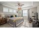 A cozy main bedroom featuring tray ceilings, plush carpet, and bright windows with natural light at 2112 Balting Glass Dr, Indian Trail, NC 28079