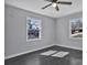 Bright bedroom featuring sleek gray walls, hardwood floors, and natural light from two windows at 2123 Ravendale St, Kannapolis, NC 28083