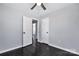 Bedroom with gray walls and hardwood floors, featuring a white paneled door and ceiling fan at 2123 Ravendale St, Kannapolis, NC 28083
