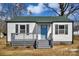Cozy single-story home featuring a light-colored exterior, gray porch and a vibrant blue front door at 2123 Ravendale St, Kannapolis, NC 28083