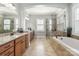 Spacious bathroom with dual vanities, a soaking tub, a walk-in shower, and neutral tile throughout at 2144 Tatton Hall Rd, Fort Mill, SC 29715