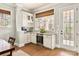 This wet bar features white cabinetry, granite countertops, wine storage, and a beverage cooler near a light-filled doorway at 2144 Tatton Hall Rd, Fort Mill, SC 29715