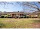 Inviting front exterior view of brick ranch with cozy covered porch and mature shrubbery at 255 Sharon School Rd, Statesville, NC 28677