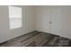 Bright bedroom with a large window and closet with doors, featuring modern wood-look flooring at 260 Mills Ave, Troutman, NC 28166