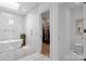 Bright bathroom showcasing freestanding tub, skylight, sleek fixtures, and access to walk-in closet at 2710 N Davidson St, Charlotte, NC 28205