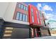 Striking modern townhouse showcases bold color and architectural details, with two garage doors and a vibrant red entrance at 2710 N Davidson St, Charlotte, NC 28205