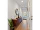 Bright hallway featuring a dark wood dresser, stylish decor, and natural light from a glass-paneled front door at 2710 N Davidson St, Charlotte, NC 28205