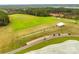 Expansive aerial view of a pristine golf course with driving range, mature trees and golf cart path at 27467 Cinderella Cir, Lancaster, SC 29720