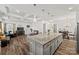 Open-concept kitchen featuring a large island, modern lighting, and seamless flow to living and dining areas at 27467 Cinderella Cir, Lancaster, SC 29720