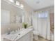 Bright bathroom featuring a vanity, a framed mirror and a shower-tub combo with neutral tile at 3011 Lauren Glen Rd, Charlotte, NC 28226